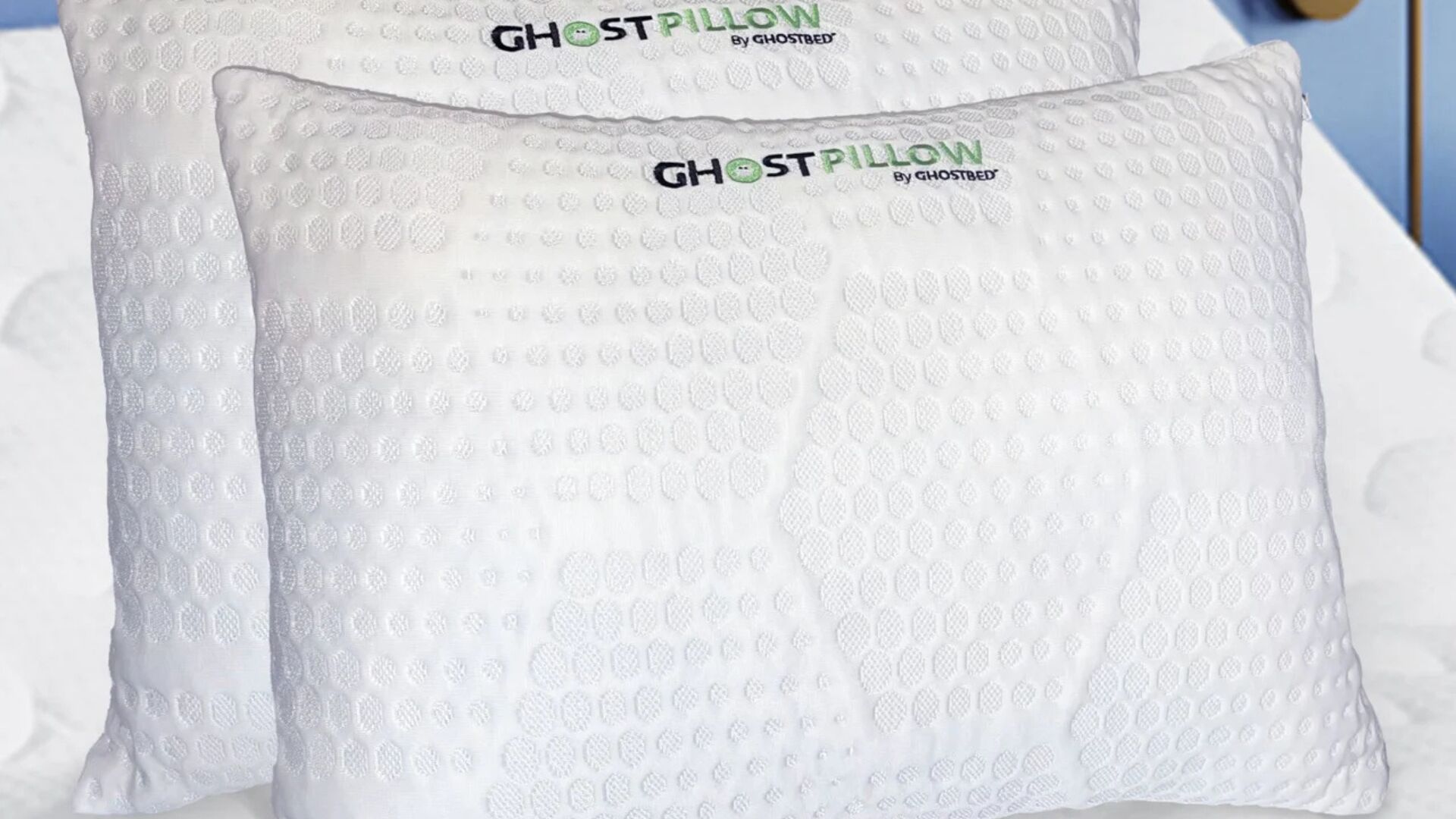 White Ghost Pillow by Ghostbed with cooling texture on a serene, inviting bed.