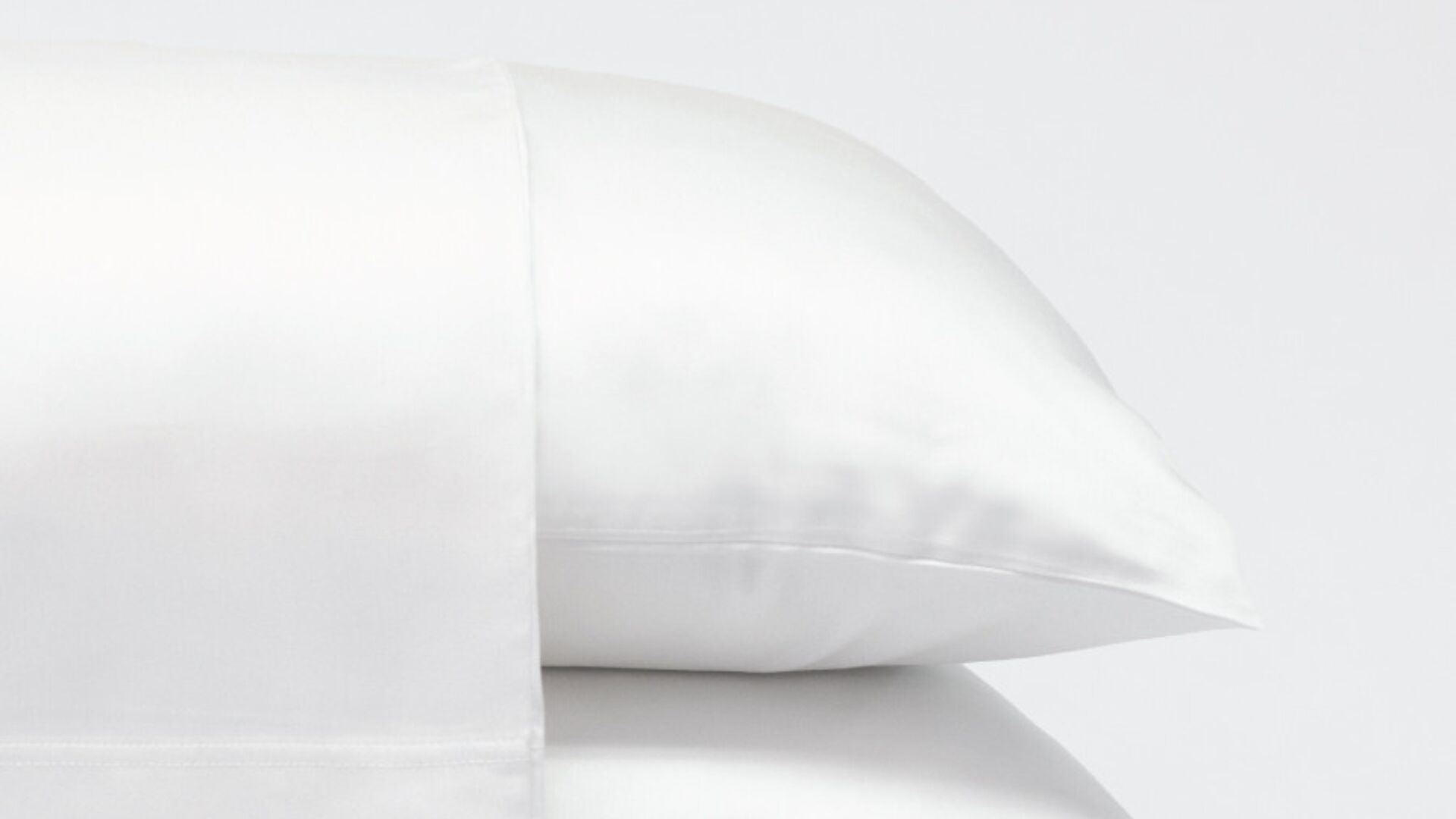 Luxurious white satin pillows showcasing elegance, comfort, and serene bedroom atmosphere.