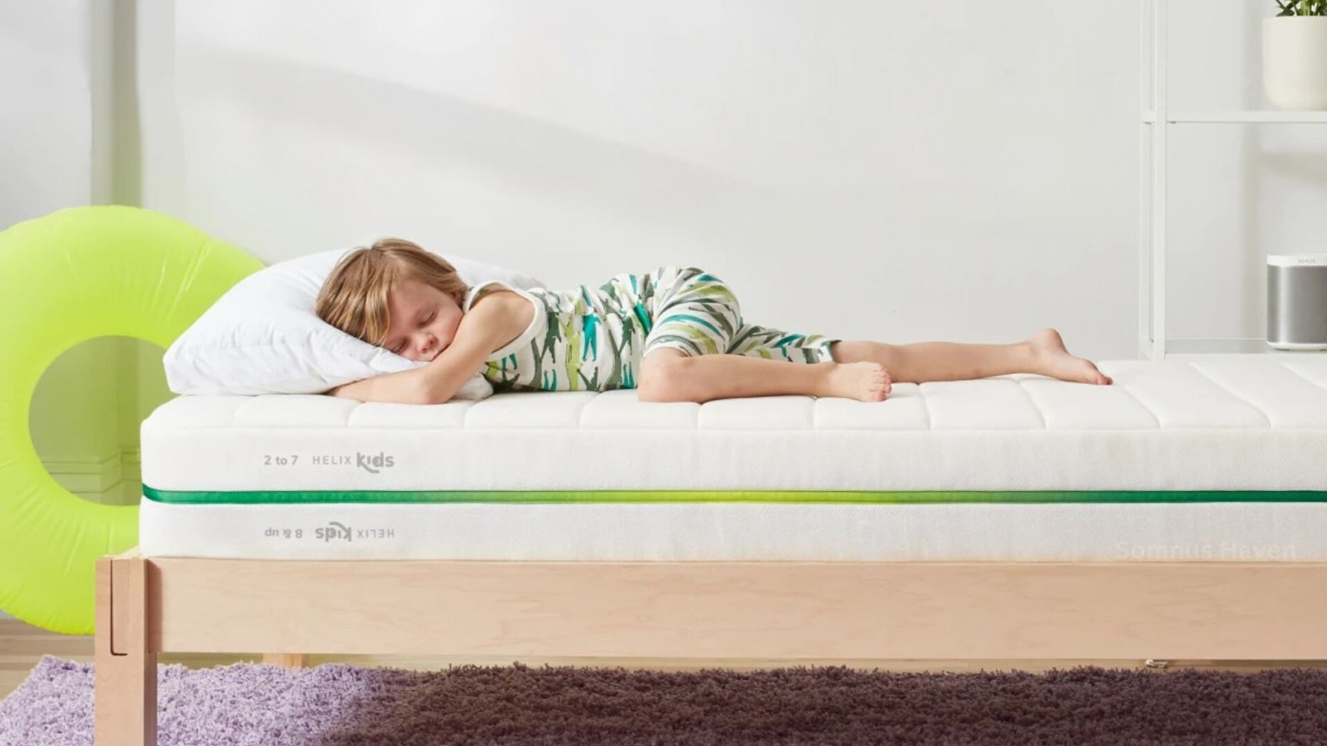 Child sleeping peacefully in cozy bedroom with striped pajamas and minimalist decor.