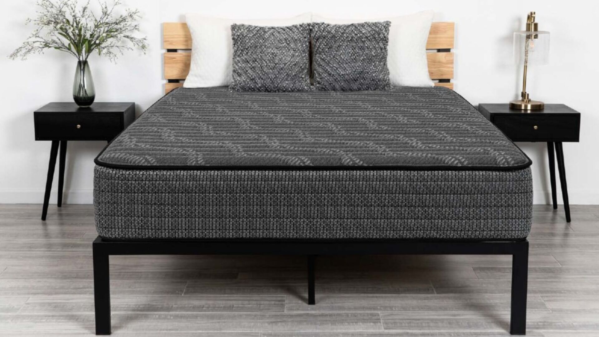 Modern bedroom with geometric mattress, minimalist nightstands, warm lamps, and light wooden floors.